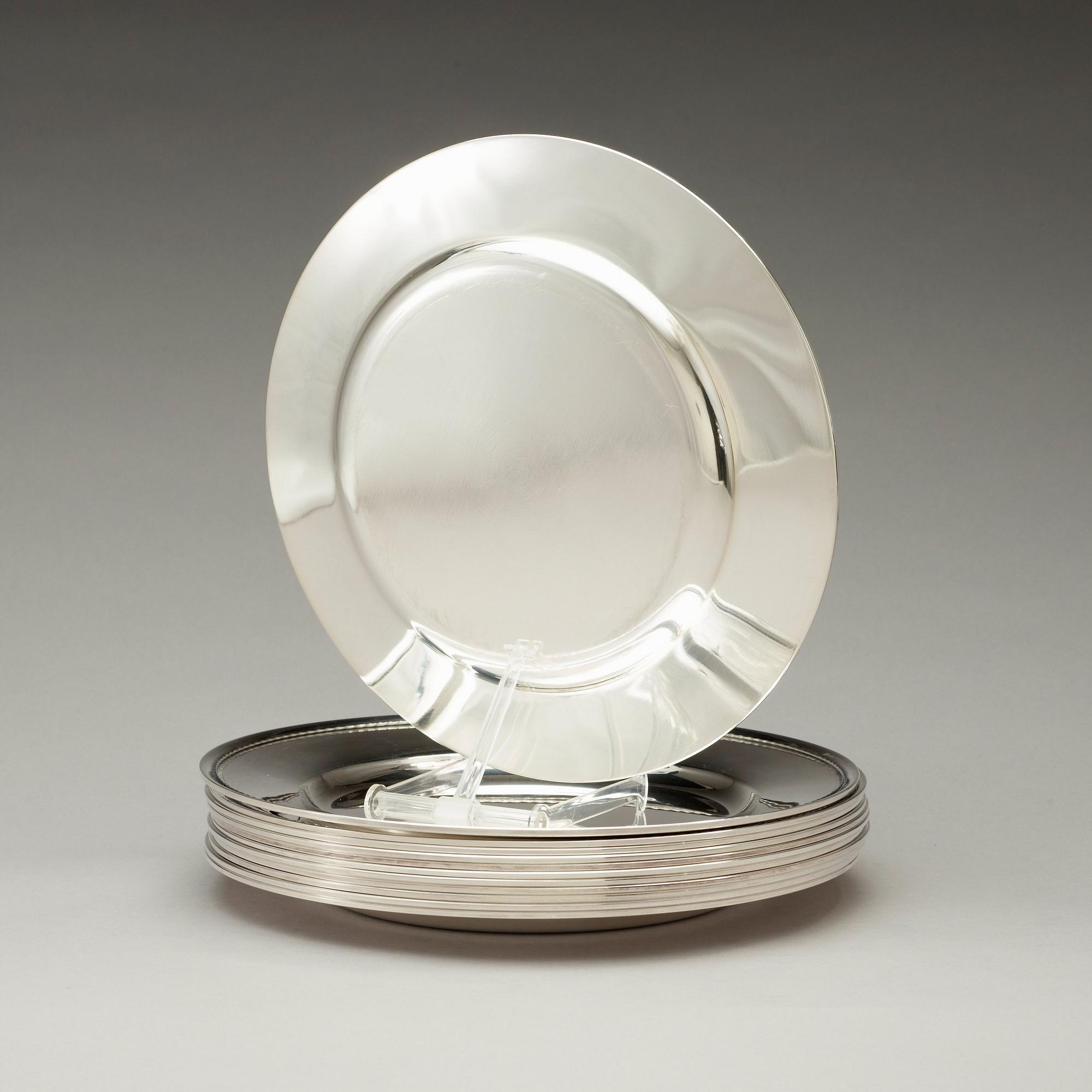 A set of 12 silver dinner plates by Guldsmedsaktiebolaget, Stockholm 1952-55.