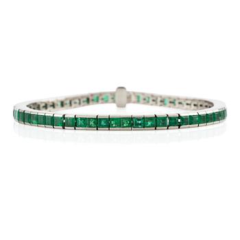 530. An 18K white gold bracelet with step-cut emeralds.