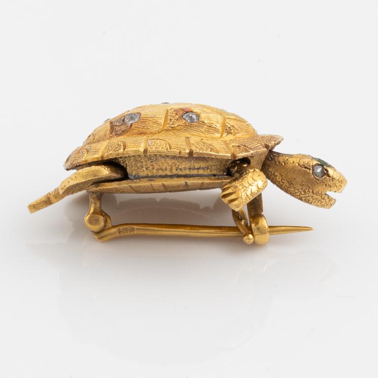 A brooch in the shape of a turtle.