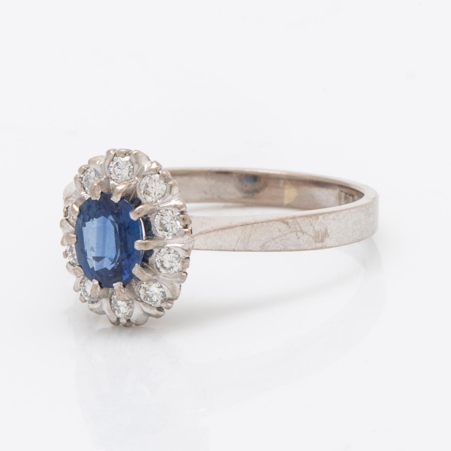 Ring 18K vitguld med 1 safir 0,77 ct och briljanter 0.23 ct enligt gravyr, Juvelia Uppsala 1991.
