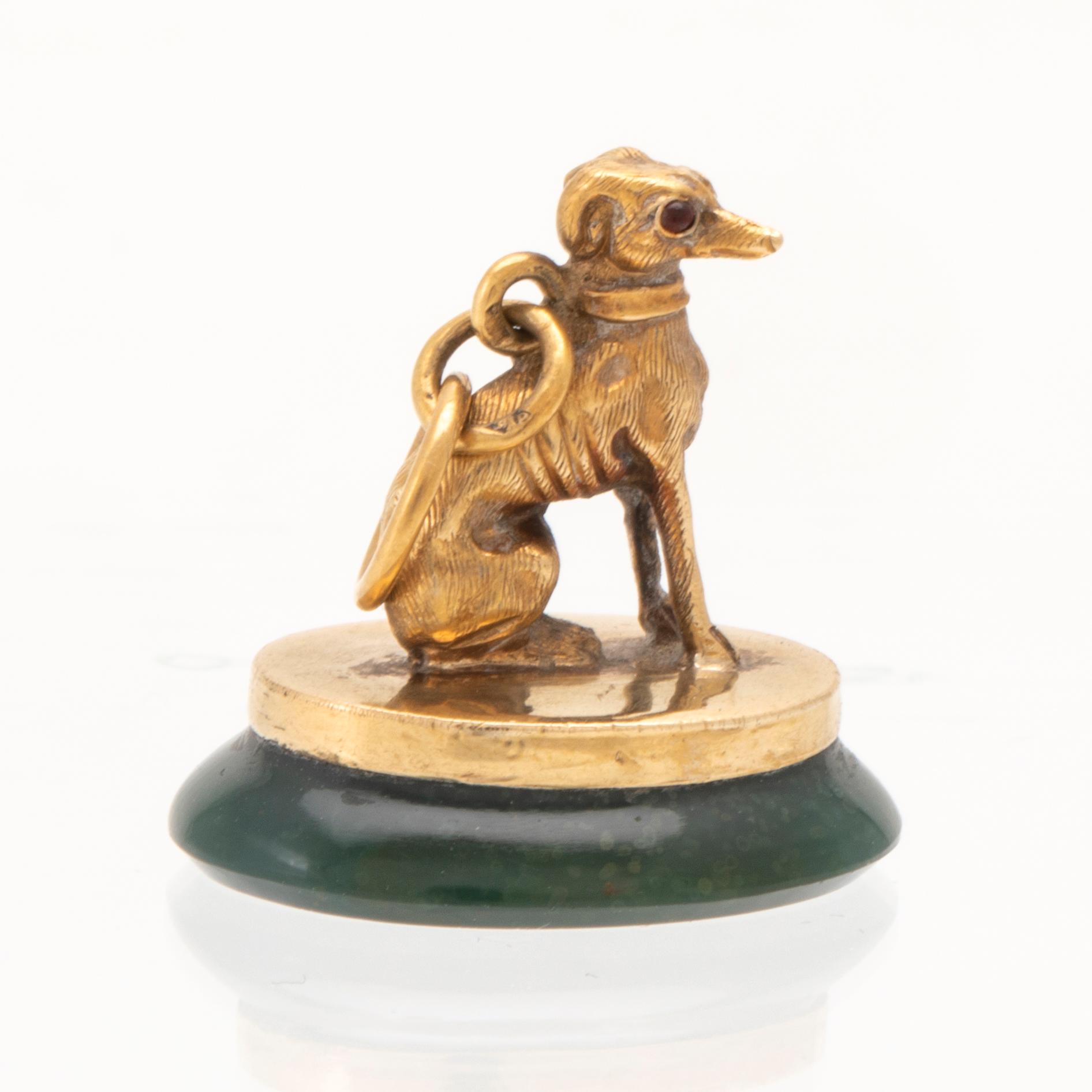 An 18K gold seal/pendant with green stone.