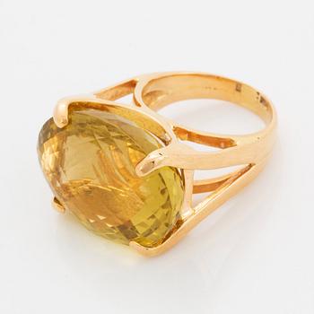 An 18K gold ring set with a faceted lemon quartz.