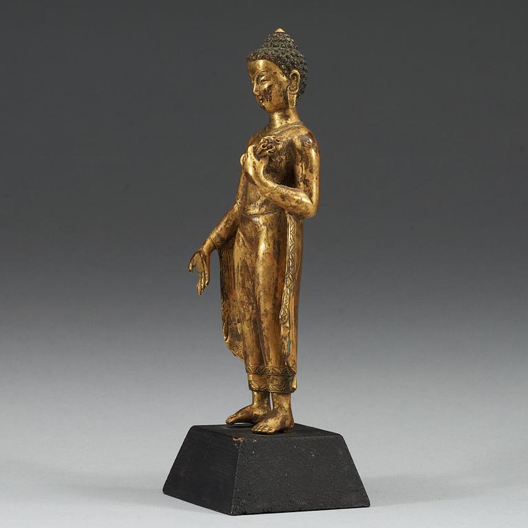A standing gilt bronze figure of Buddha, Nepal, 19th Century.