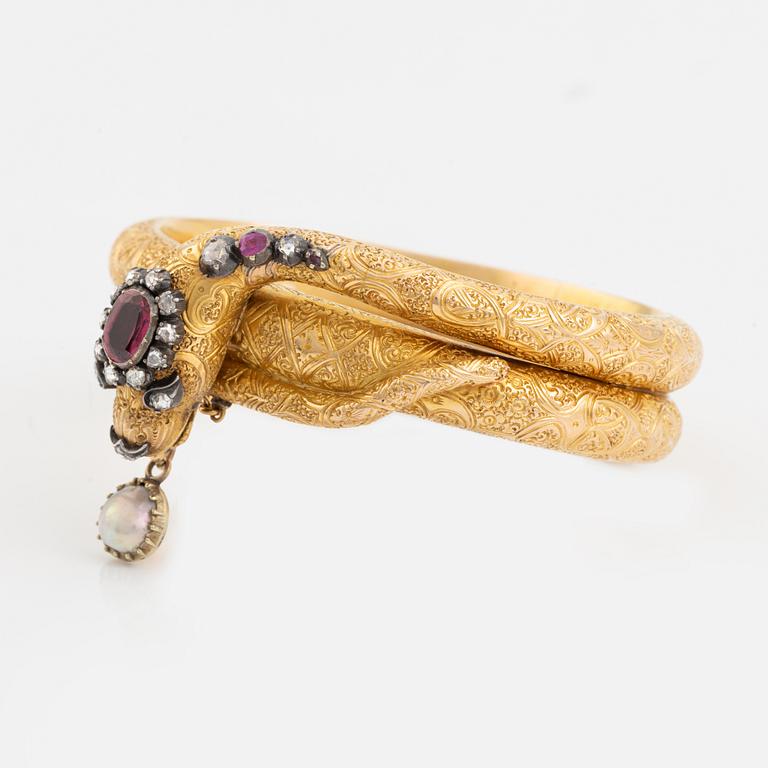 A Victorian snake bracelet in 14K gold with rose-cut diamonds, red stones and a half pearl.