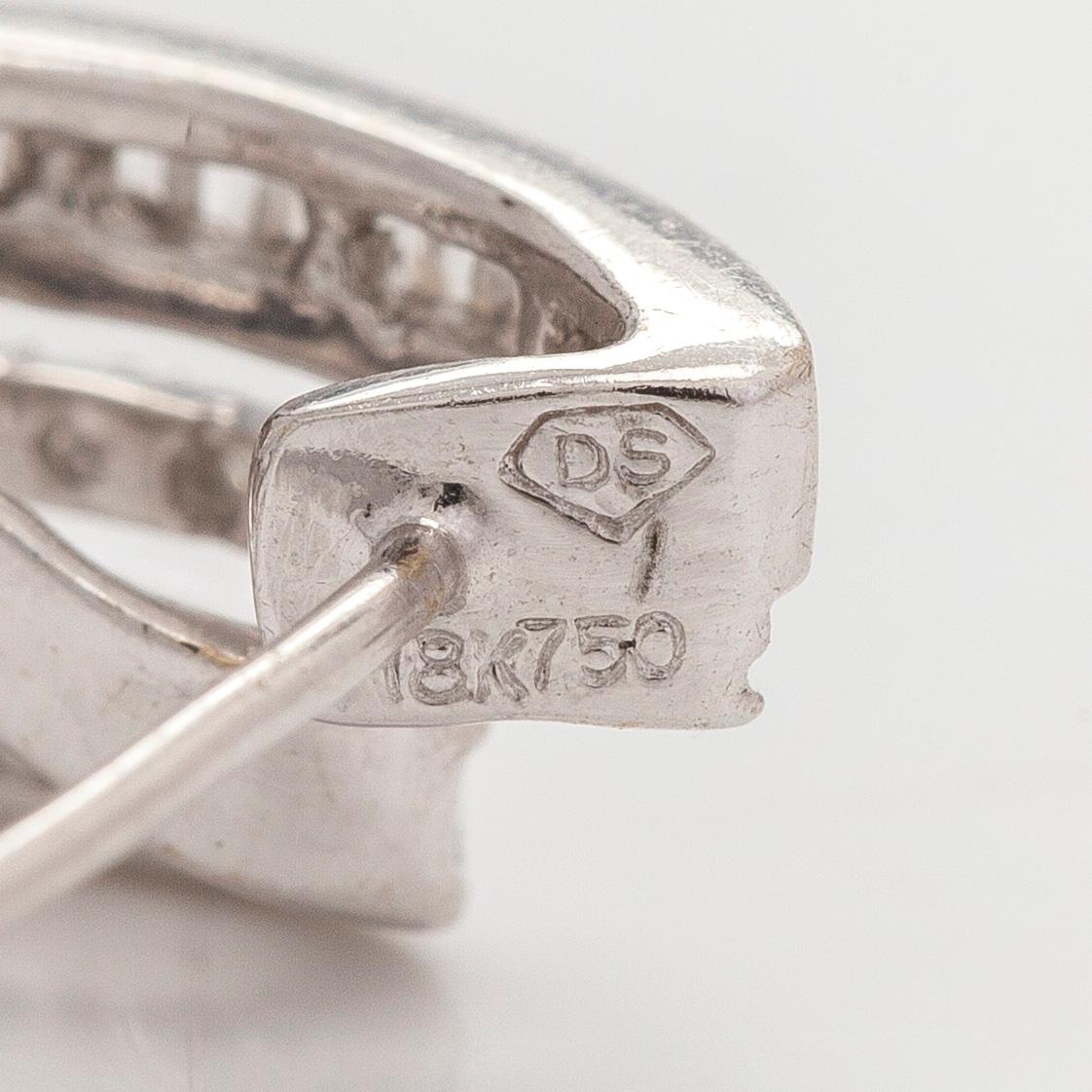 A pair of 18K white gold earrings, set with brilliant- and baguette-cut diamonds.