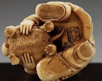 A carved ivory figure of two boys playing with at turtle, Qing dynasty.