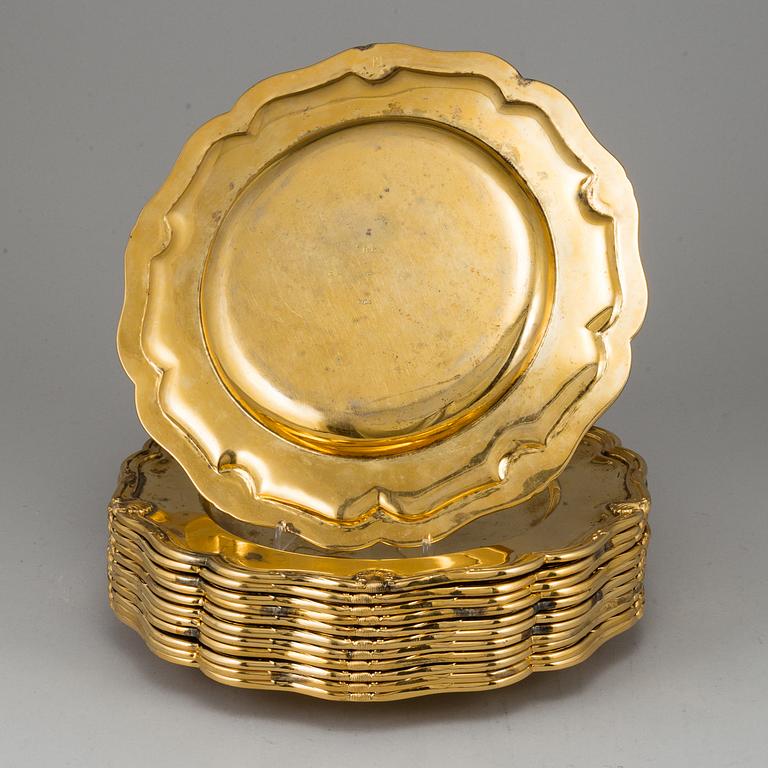 A German set of twelve 19th century silver-gilt plates, mark of Hossauer, Berlin. Rokoko-style.