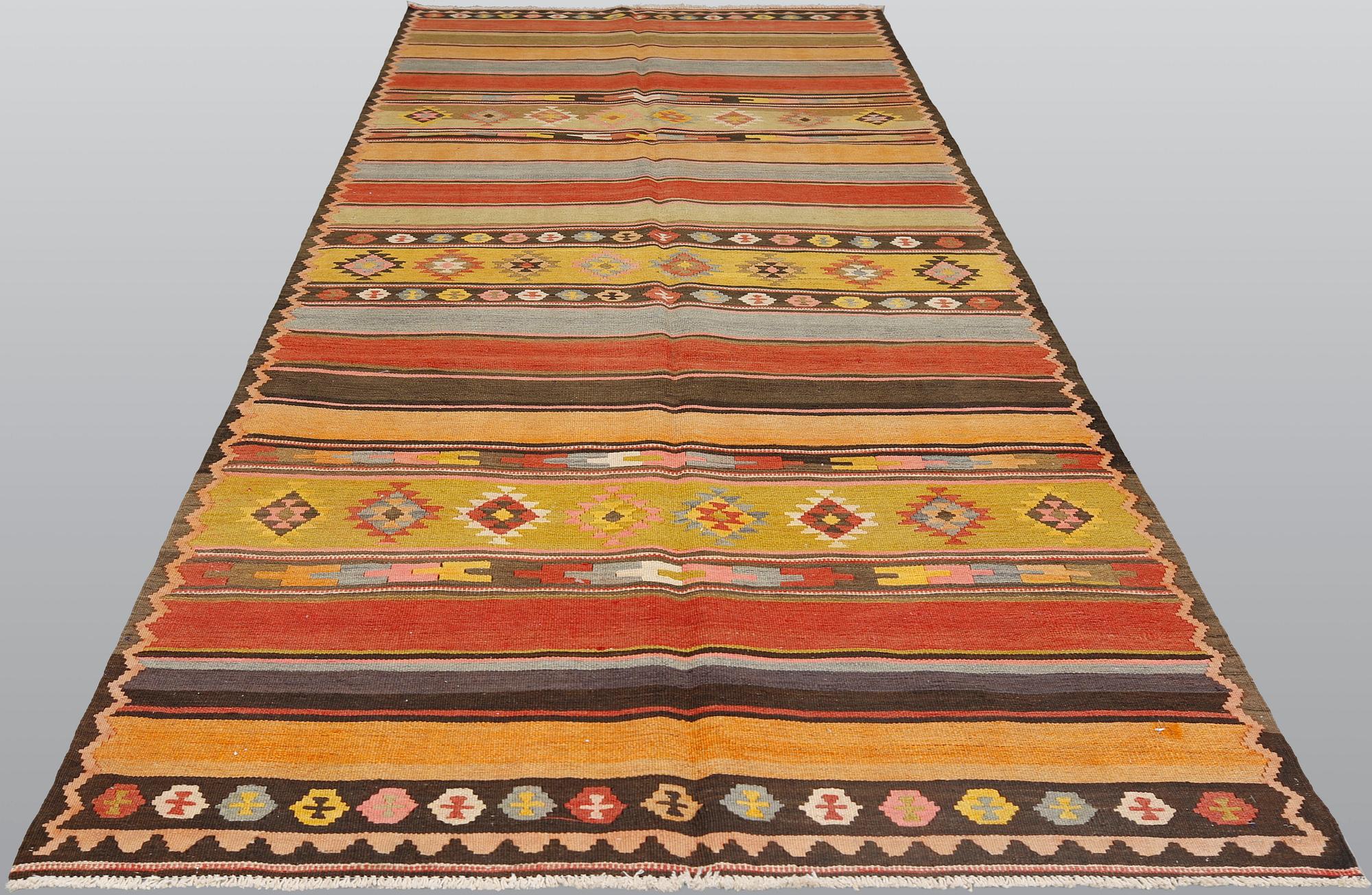 A semi-antique Nomadic Kilim rug, approx. 383 x 153 cm.