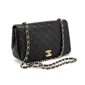 CHANEL, a black leather quilted purse with shoulder strap.