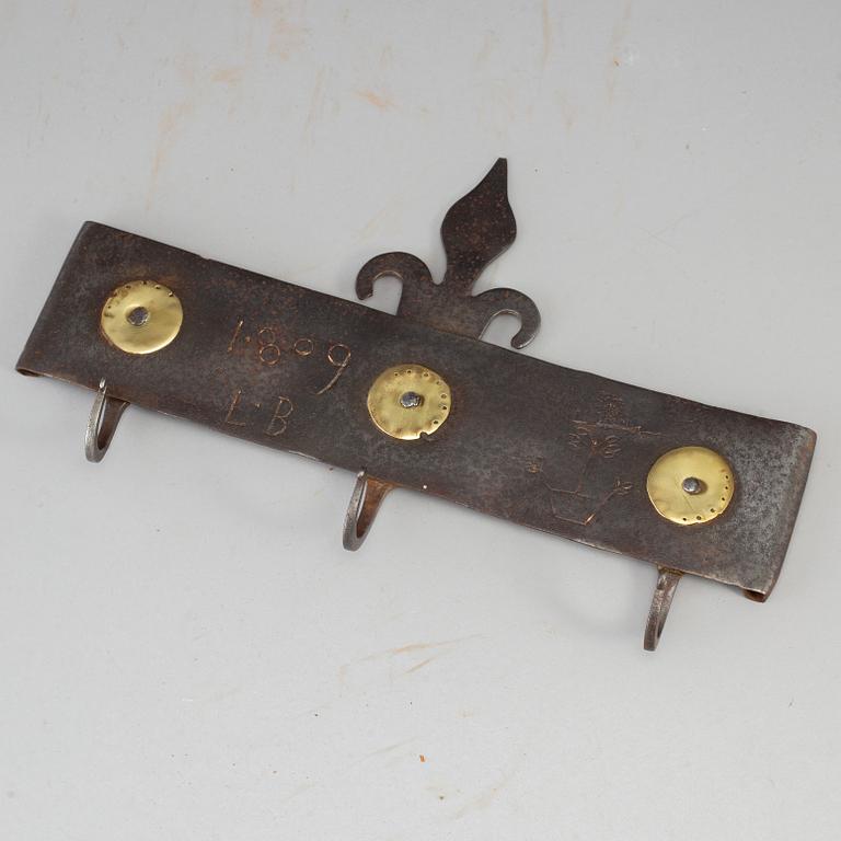 An iron wall hanger, dated 1809.