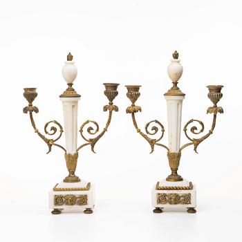 A Louis XVI-style mantle clock and a pair of candelabras. Early 20th century.