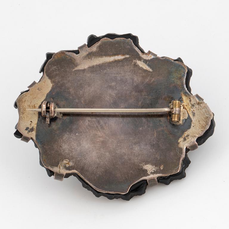 Carved possibly jet/coal and silver brooch.