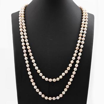 Long cultured pearl necklace with an 18K white gold clasp set with emeralds.