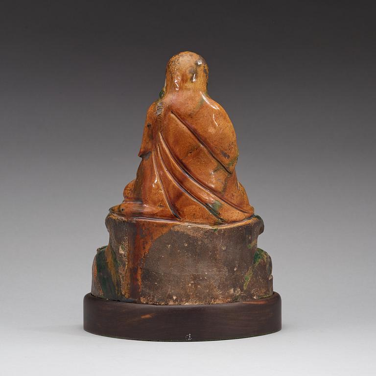 A seated green and yellow glazed deity, Ming dynasty (1368-1644).