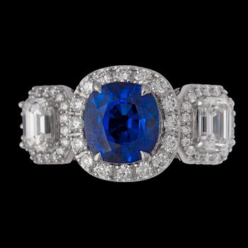 1390. A cushion cut blue sapphire 3.06 cts, and emerald-and brilliant cut diamond ring.