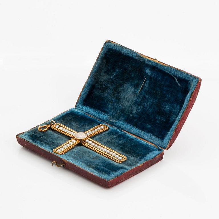 An 18K gold and pearl cross pendant with a gold chain.