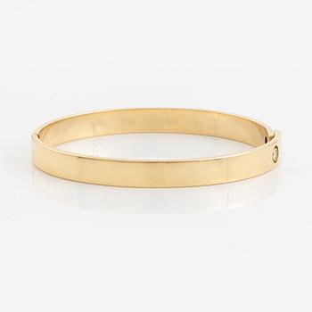 A Cartier "Anniversary Bracelet" in 18K gold set with a round brilliant-cut diamond.