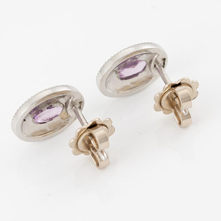 A pair of 14K gold earrings with pink faceted sapphires and round brilliant-cut diamonds.