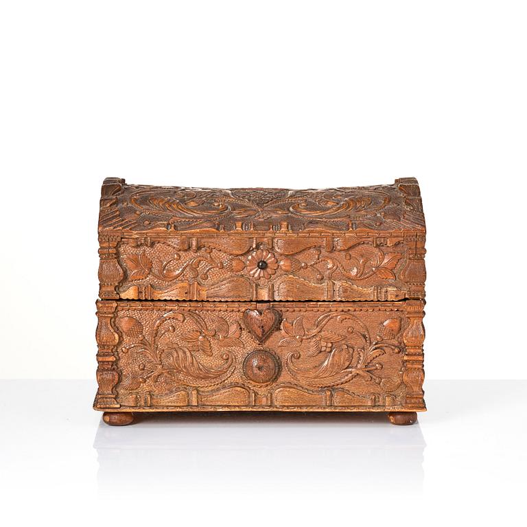 A baroque wedding casket, carved wood, dated 1725.