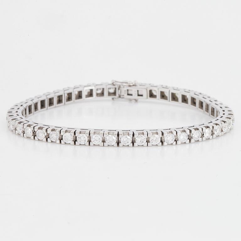 An 18K white gold tennisbraclet set with round brilliant-cut diamonds.