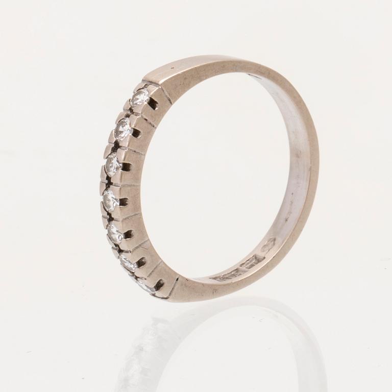 A half eternity ring in 18K white gold set with round brilliant-cut diamonds.