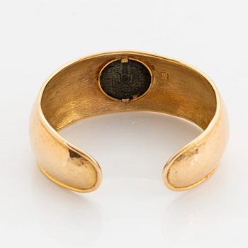 An 18K gold bangle set with an ancient coin.