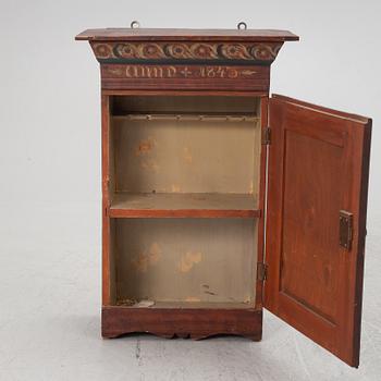 A wall cabinet, dated 1843.