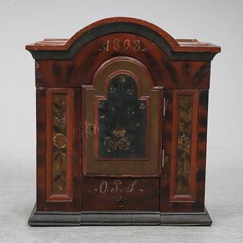 A painted pine wall cabinet, dated 1808.