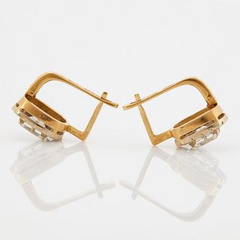 A pair of earrings in 18K gold set with emerald-cut diamonds.