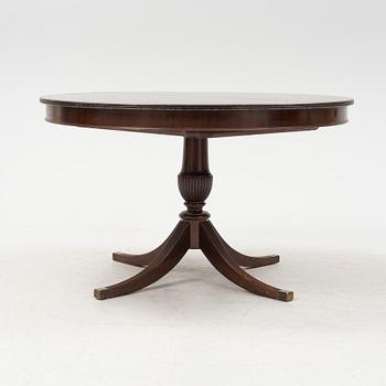 A round mahogany dining table with three additional leaves.