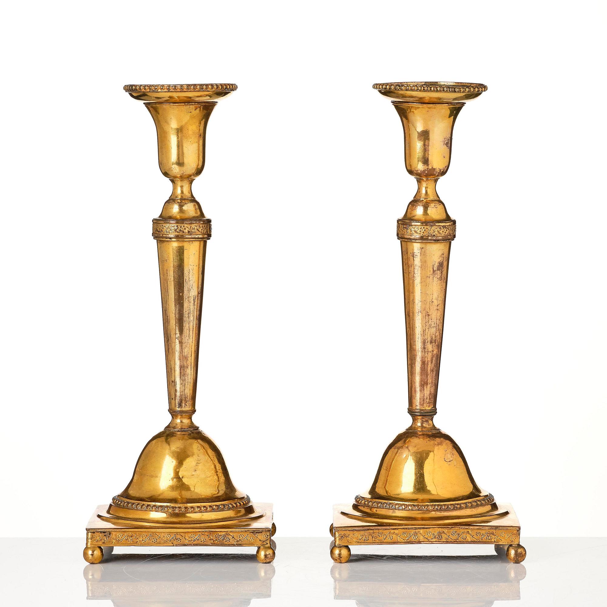 A pair of late George III gilt-copper candlesticks, early 19th century.