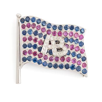 565. A brooch with Broströms flag in 18K white gold with monogram.