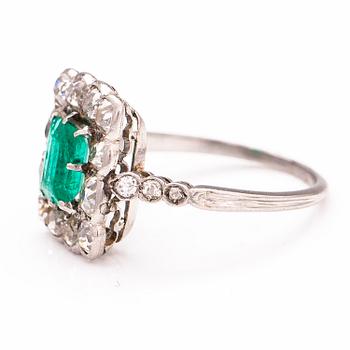 A platinum ring with an emerald ca 0.71 ct and old cut diamonds ca 1.66 ct in total.