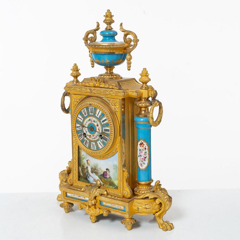 A French Louis XVI-style mantel clock and a pair of candelabra, late 19th Century.