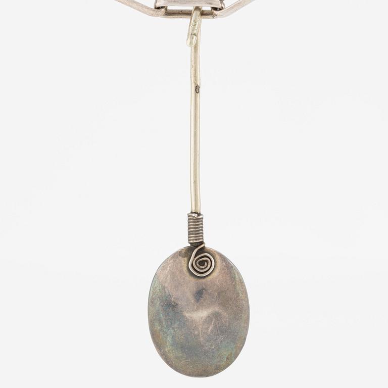 Pendant with silver chain and blue stone, likely moonstone.