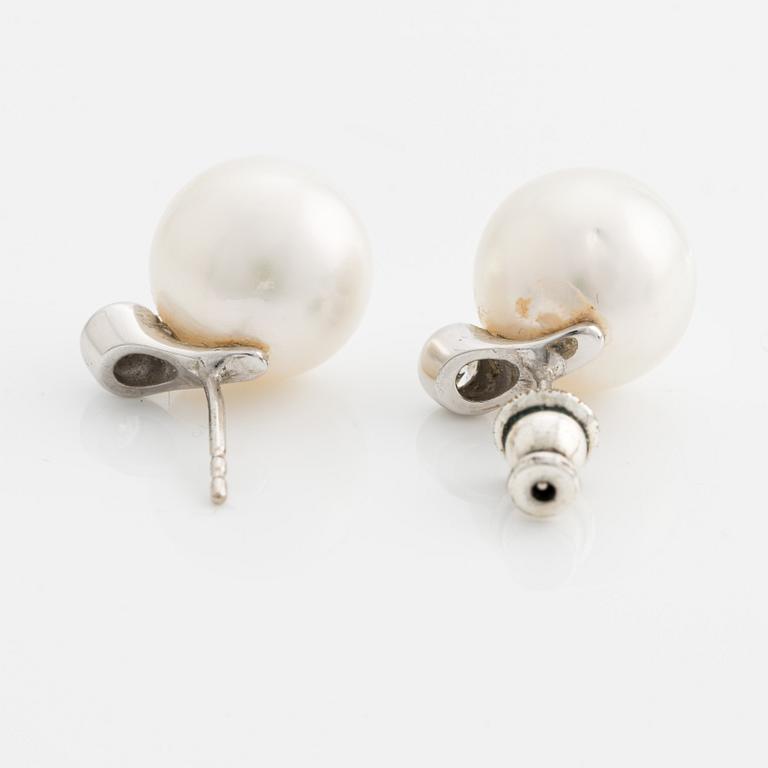 A pair of 18K gold earrings with cultured pearls and round brilliant-cut diamonds.