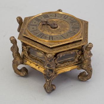 A gilded brass baroque travel clock from around 1700, with original case.