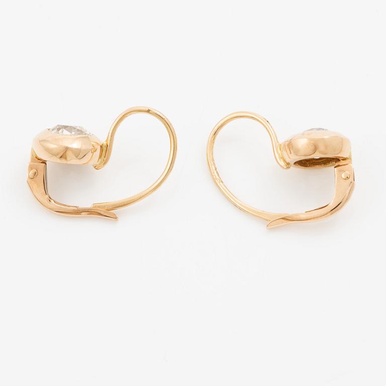 A pair of earrings in 18K gold set with two old-cut diamonds.