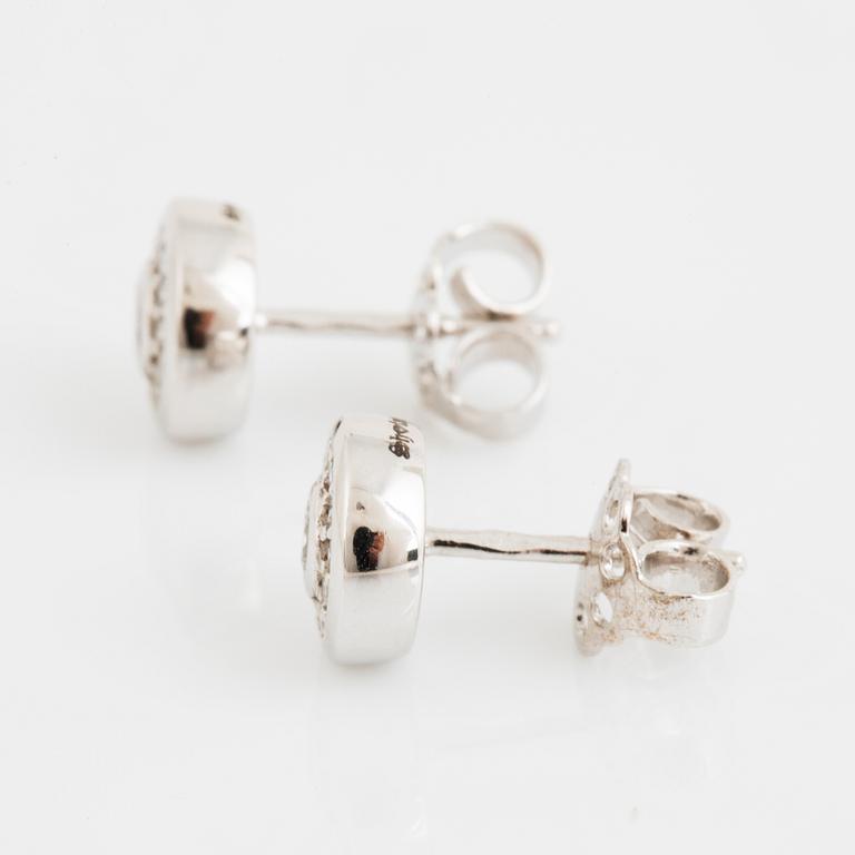 A pair of 14K gold earrings set with round brilliant-cut diamonds.
