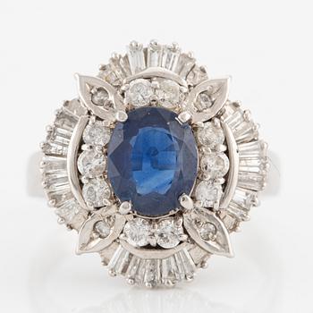 Ring in platinum set with a faceted sapphire and round brilliant- and baguette-cut diamonds.
