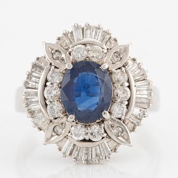 Ring in platinum set with a faceted sapphire and round brilliant- and baguette-cut diamonds.