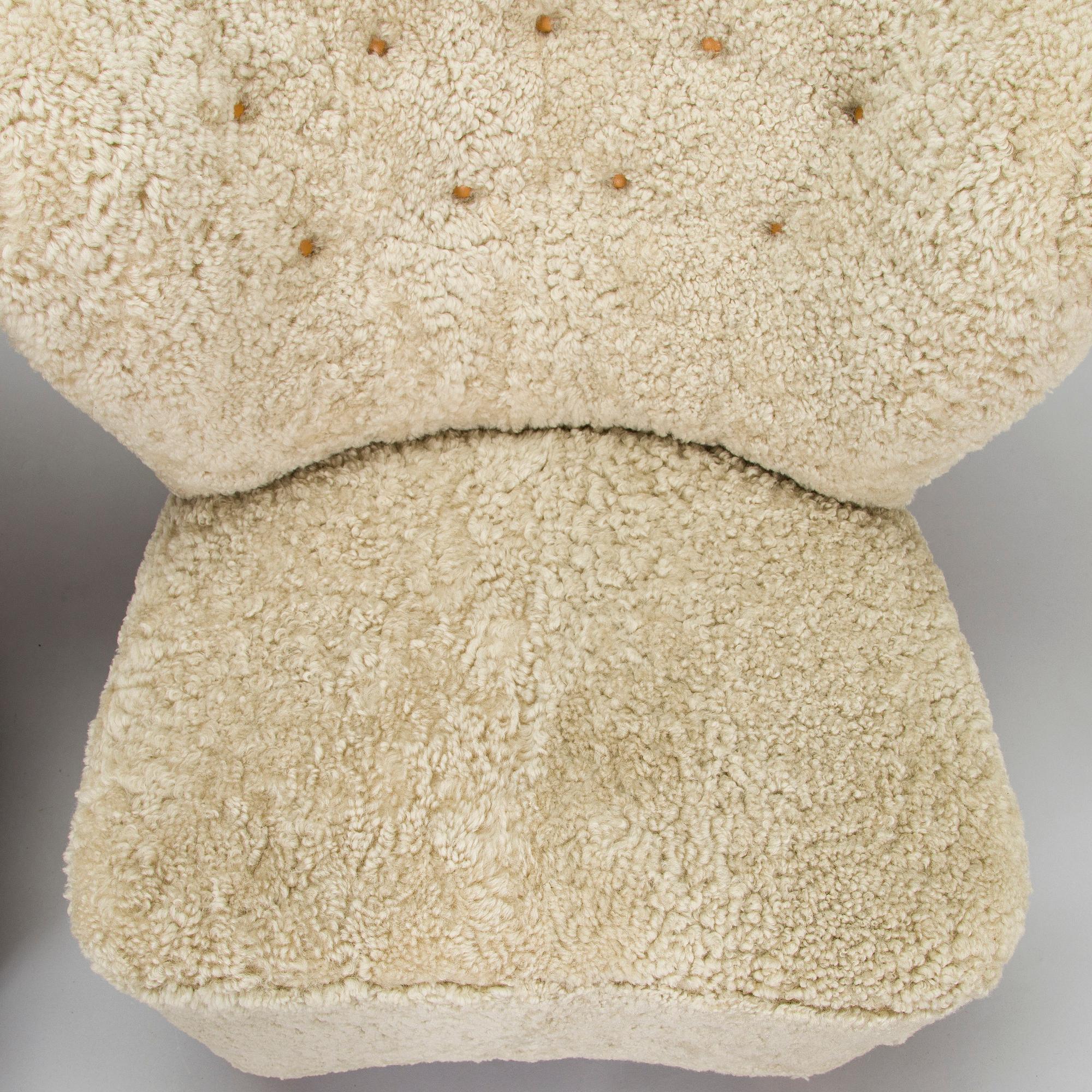 A pair of mid-20th century armchairs in sheepskin.