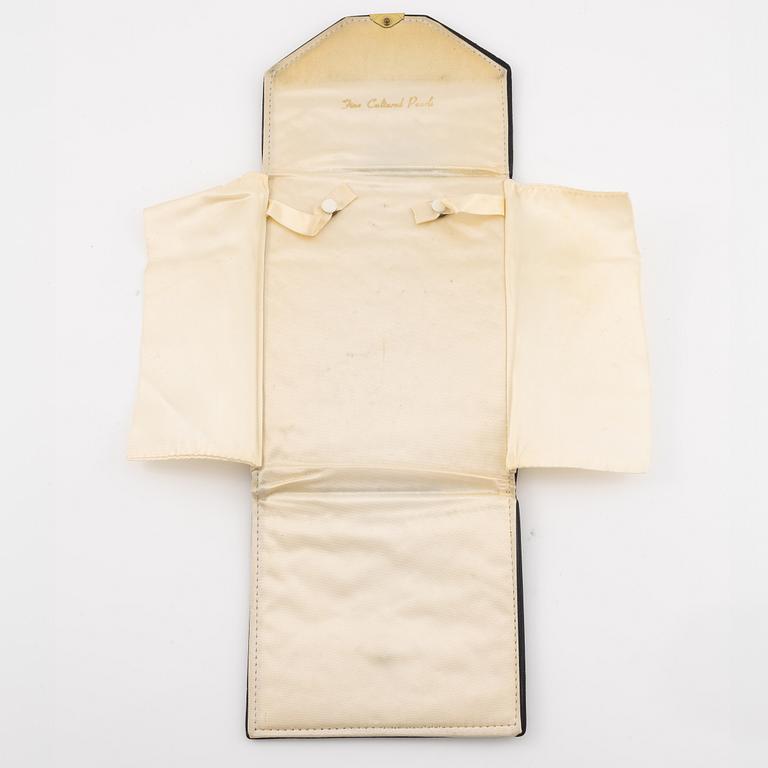 Multi-strand pearl necklace with two clasps set with carved coral, cabochon-cut tourmaline, and brilliant-cut diamonds.