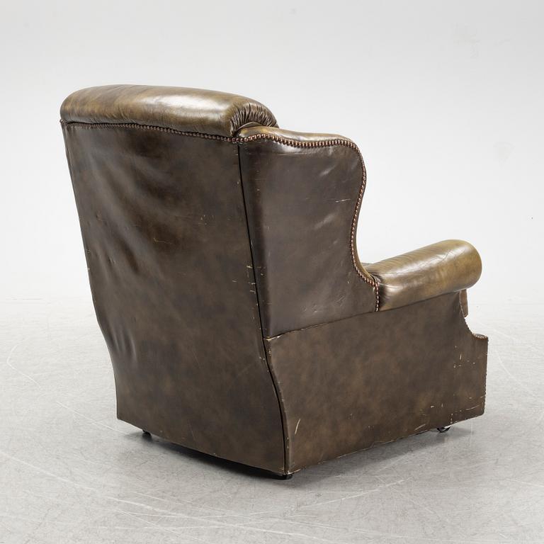 A leather upholstered easy chair with stool, second half of the 20th Century.