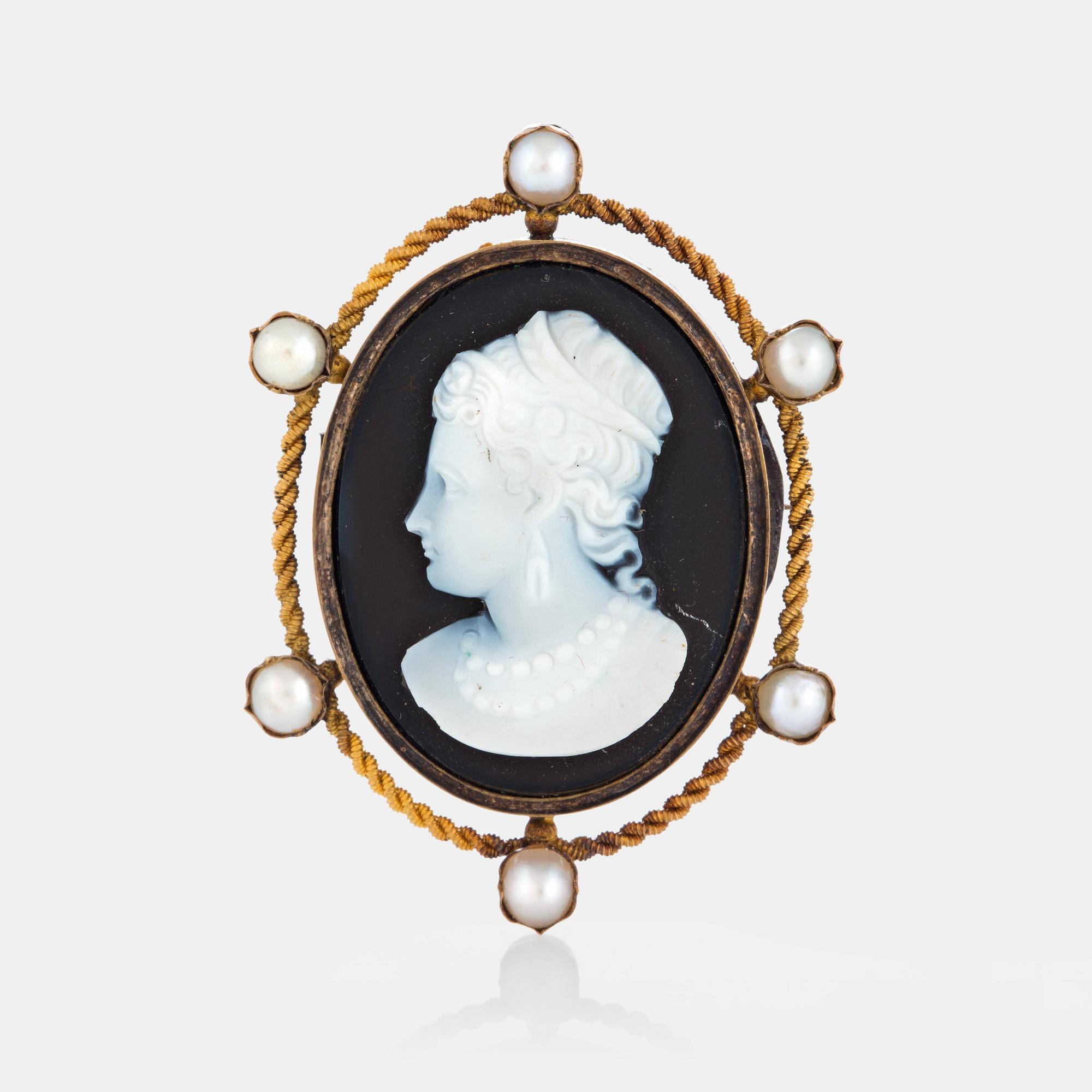 A hard stone cameo brooch in 18K gold set with pearls.