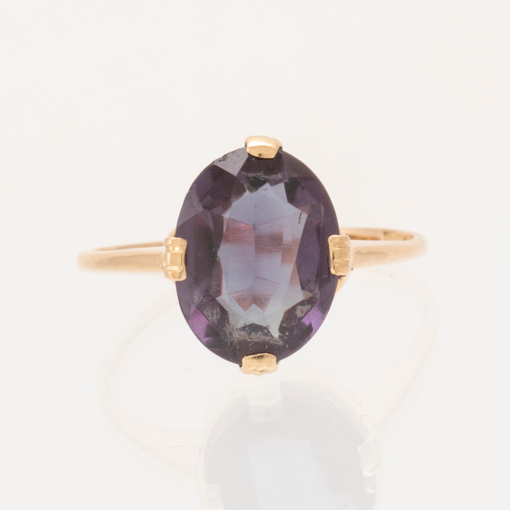 An 18K gold ring set with a synthetic colourchange purple sapphire.
