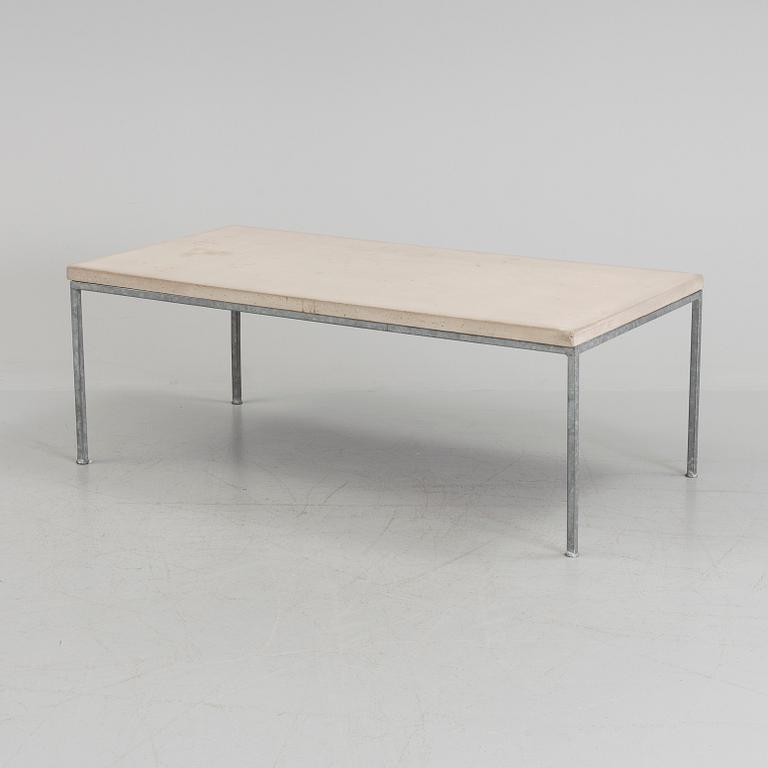 A modern sofa table with concrete top and steel legs.