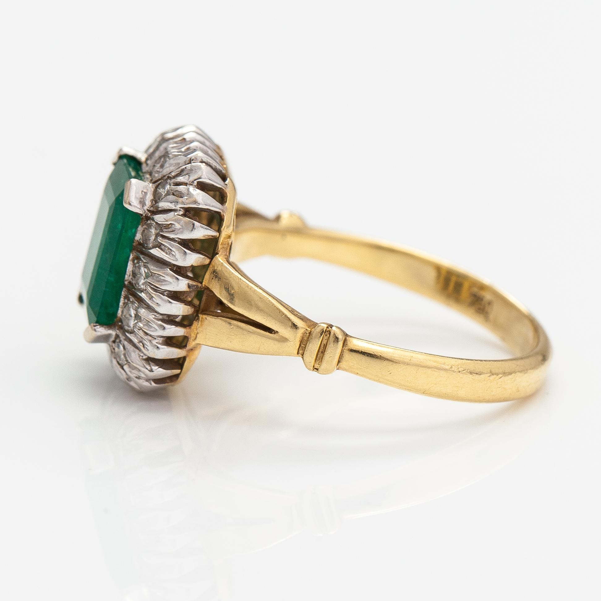 An 18K gold ring with diamonds ca. 0.21 ct and an emerald.