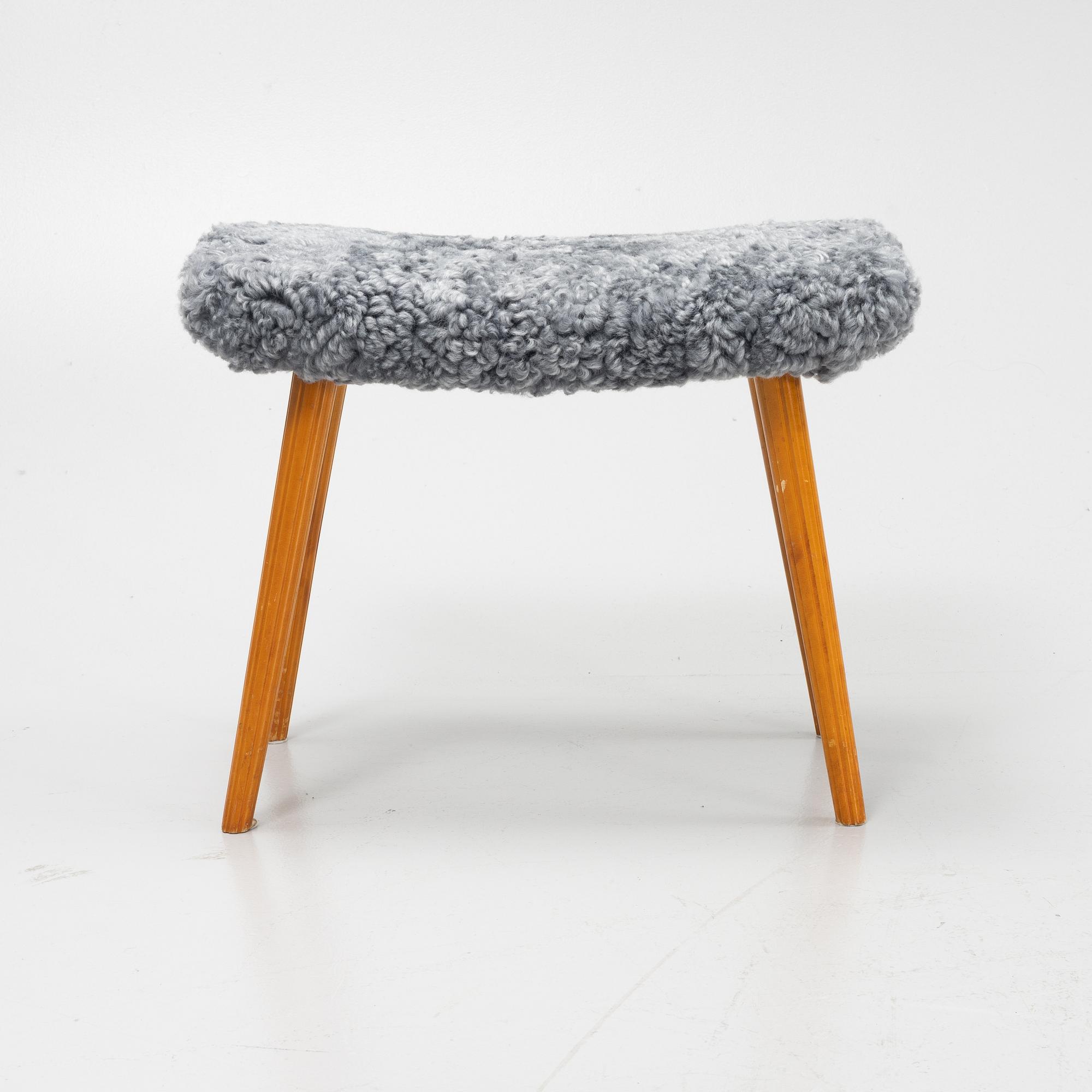 A mid 20th Century stool with new sheepskin upholstery.
