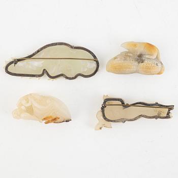 Two Chinese stone figurines and two brooches, 20th century.